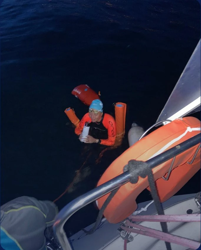 Ravitaillement de nuit depuis le bateau, bouée orange autour du buste